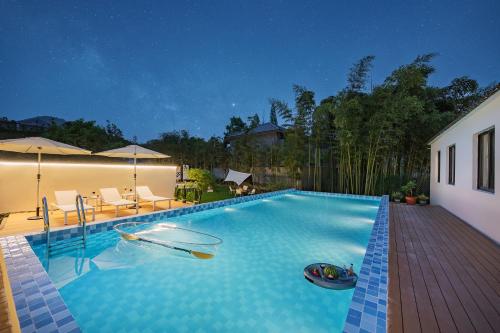 una piscina con una barca al centro di 莫干山雅泉山居 a Deqing