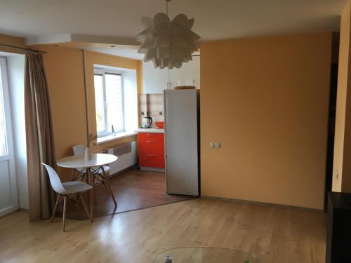 a kitchen with a table and a refrigerator at Apartment on the 4th floor in Jūrmala