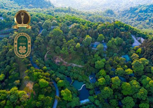 an aerial view of a forest with a sign and a river at Melia Ba Vi Mountain Retreat in Hanoi