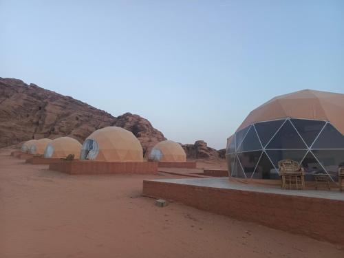 a row of domed tents in the desert at Wadi Rum Maracanã camp in Wadi Rum