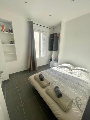 une chambre avec un grand lit avec une fenêtre dans l'établissement Cosy appartement - Vieux port, à Antibes