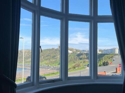 a window with a view of a beach and the ocean at Hotel Ellenby in Scarborough