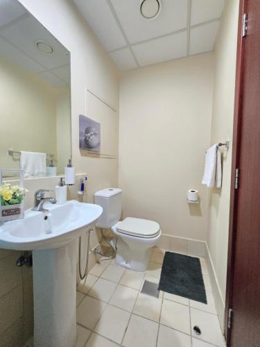a white bathroom with a sink and a toilet at 1 WORLD, Premium Hostel, JBR, Near Metro and Beach in Dubai