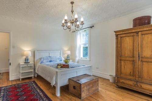 a bedroom with a bed and a chandelier at Islay House - Blue Room in Woodend