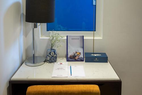 une table avec une lampe et un livre sur celle-ci dans l'établissement Hanoi Brilliant Hotel & Spa, à Hanoï