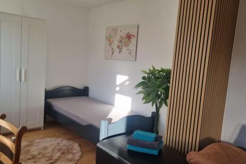 a bedroom with a bed and a table with a plant at Wohnen in Niederweimar zwischen Marburg und Gießen in Niederweimar