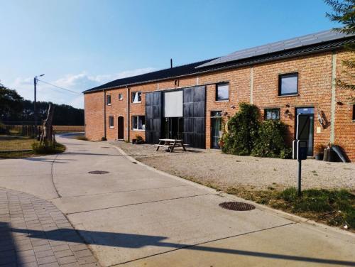 a brick building with a picnic table in front of it at Smishoeve "Huis van de Raaf" in Heers
