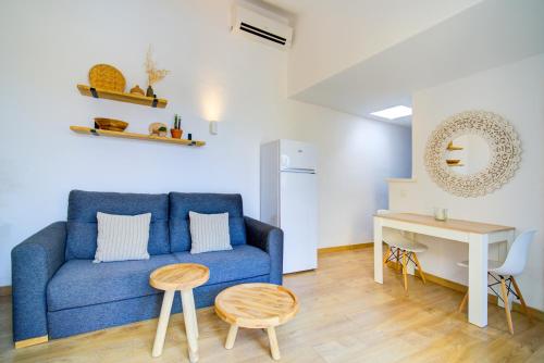 un salon avec un canapé bleu et une table dans l'établissement Surmar - Apartamento con piscina en Cap d'Artrutx, à Cala'n Bosch