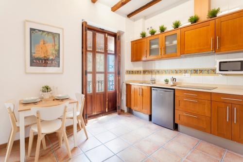 a kitchen with wooden cabinets and a table at Sunny Modern Flat by Mercado Central in Valencia