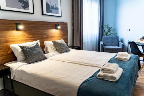een hotelkamer met een groot bed met handdoeken erop bij Sleep Port in Gdańsk