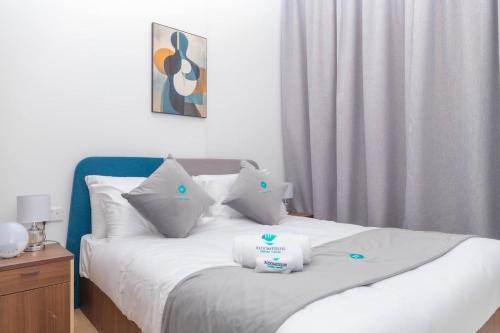 Bloomfields -1br Oasis 2 في أبوظبي: غرفة نوم بسرير ذو شراشف ووسائد بيضاء