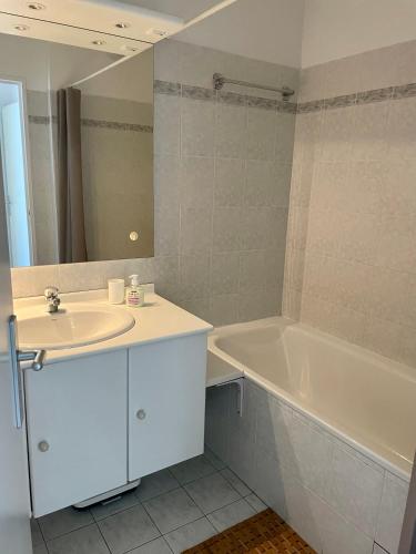 une salle de bain avec un lavabo et une baignoire dans l'établissement Joli appartement avec piscine, à Antibes