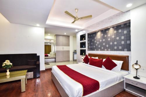 a bedroom with a large white bed with red pillows at Pinaz Royale in Amritsar
