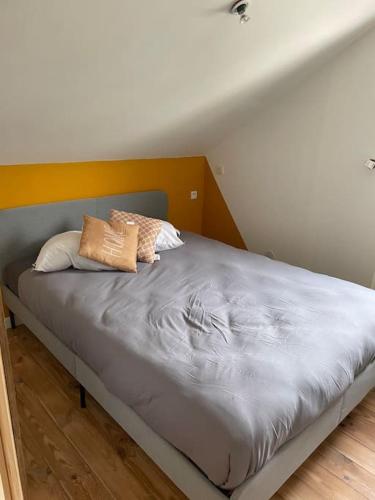 un lit avec deux oreillers dessus dans une chambre dans l'établissement Chalet 6-8 personnes avec jeux et jaccuzi - Nahleo Chalet, à Villers-lès-Pots