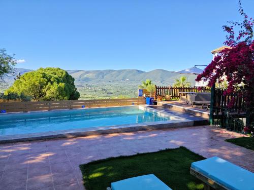 uma piscina com vista para as montanhas em Villa Pigi em Méson Yerakaríon