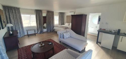 a living room with a couch and a bed at Acacia Lodge in Bloemfontein
