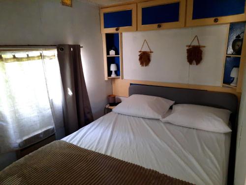 Schlafzimmer mit einem Bett mit weißer Bettwäsche und einem Fenster in der Unterkunft Conteneur maritime in Ambon