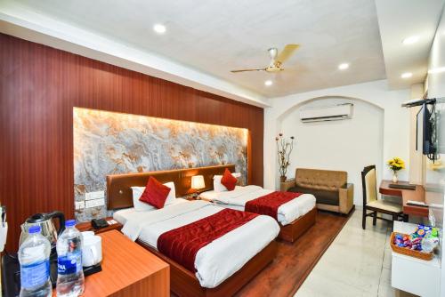 a hotel room with two beds and a desk at Pinaz Royale in Amritsar