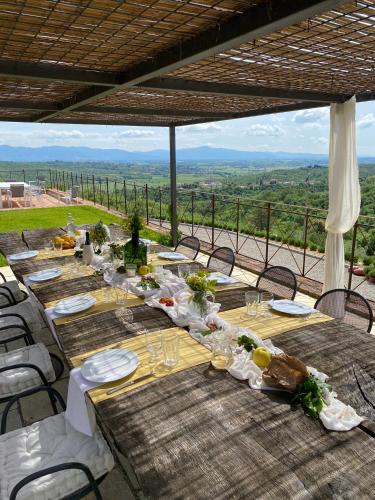 a long table with plates and glasses on top at Podere Cavalbianco in Ciggiano