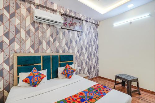 een slaapkamer met een bed en een muur met patronen bij FabHotel Jimmy Palace in Tājganj