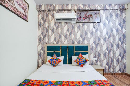 een slaapkamer met een bed met kleurrijke kussens erop bij FabHotel Jimmy Palace in Tājganj