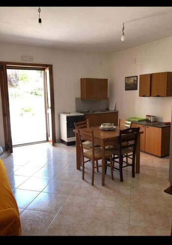 uma cozinha e sala de jantar com mesa e cadeiras em Dorotea em Contursi Terme