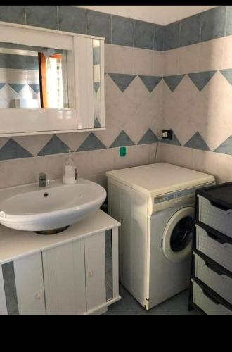 uma casa de banho com um lavatório e uma máquina de lavar roupa em Dorotea em Contursi Terme