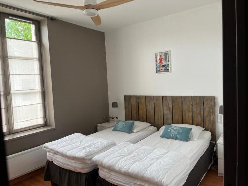 a bedroom with a large bed with blue pillows at Jolie location contemporaine dans Saint Martin de Ré in Saint-Martin-de-Ré