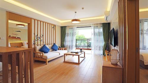 a living room with a white couch and a tv at 从化方圆·云雅酒店 in Guangzhou