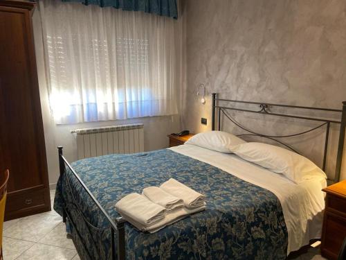 a bedroom with a bed with towels on it at Albergo B&B Antica Trattoria Bacco in Circello