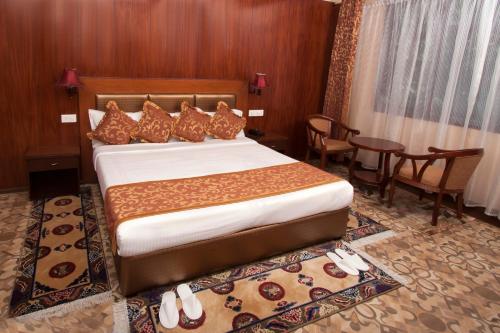 a hotel room with a bed and a table and chairs at Yarlam Portico in Gangtok