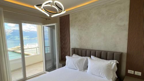 a bedroom with a bed with a view of the ocean at Hotel Demoli in Pogradec