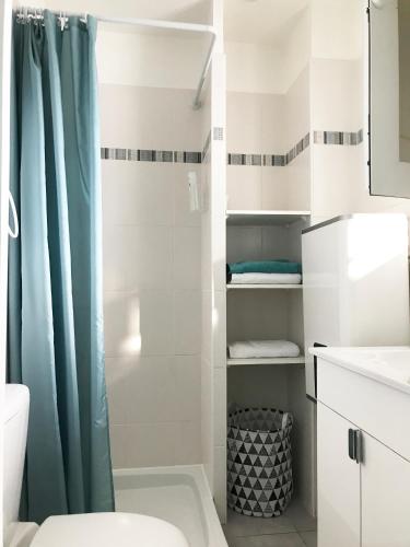 une salle de bain avec un rideau de douche et des toilettes dans l'établissement Plage et hippodrome, à Cagnes-sur-Mer