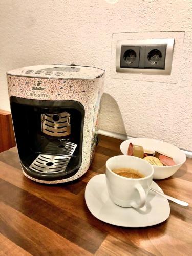 a cup of coffee on a table next to a toaster at Ferienwohnung Am Flörbach in Ahaus