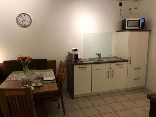 cocina y comedor con mesa y microondas en Ferienwohnung &#132Am Flörbach&#147, en Ahaus