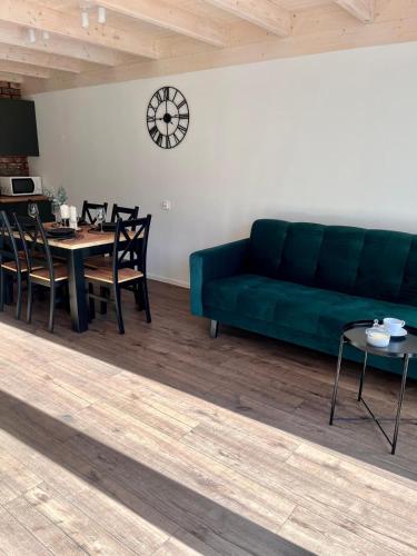 a living room with a green couch and a table at DOMIKO in Nickelswalde