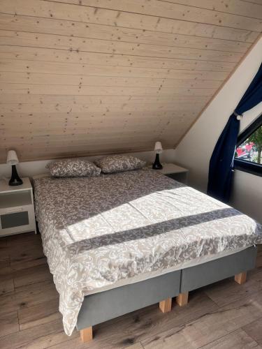 a bed in a room with a wooden ceiling at DOMIKO in Nickelswalde