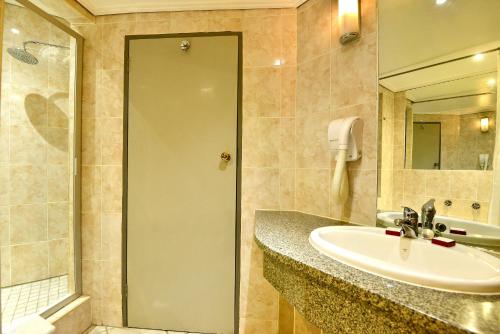 a bathroom with a sink and a shower at Cresta Jameson Hotel in Harare