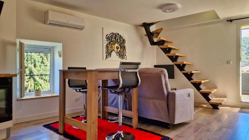 een woonkamer met een bureau en een trap bij La Magnanerie in Les Assions