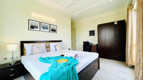 Un dormitorio con una cama con una manta azul. en BluO Lake Facing 1BHK NewTown, Terrace Garden, Gym, en Calcuta