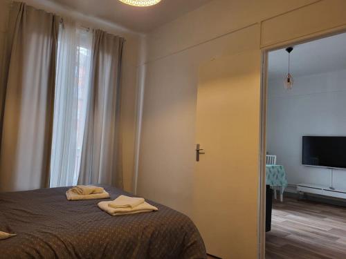a bedroom with a bed with two towels on it at Cosy Appartement Paris Ouest in Suresnes