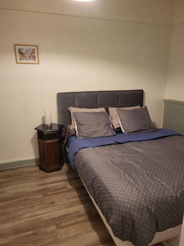 - une chambre avec un lit avec des oreillers et une table dans l'établissement Cosy Appartement Paris Ouest, à Suresnes