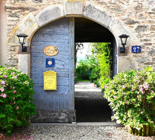 una entrada a una puerta azul con un cartel en ella en Chambres d'Hôtes Le Puits d'Amour, en Mirandol-Bourgnounac