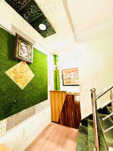 a hallway with a green wall and stairs at Shri Hari Cottage in Mathura