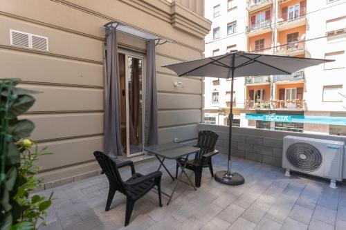 a patio with a table and chairs and an umbrella at Adam Eric in La Spezia