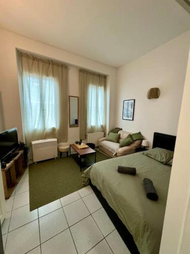 une chambre avec un lit et un salon dans l'établissement Le cactus, proche de la gare, à Toulouse