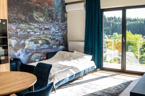 a bedroom with a bed and a large window at Apartamenty Lesko 36 in Lesko