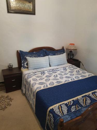 1 dormitorio con 1 cama con edredón azul y blanco en Marrakech, en Marrakech
