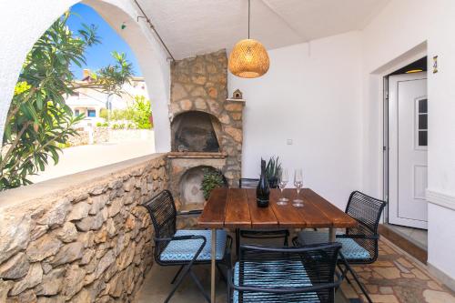 een eetkamer met een tafel en een stenen open haard bij Apartments Soul in Krk