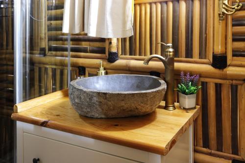 a bathroom with a stone sink on a wooden counter at Coco Banane in Anduze
